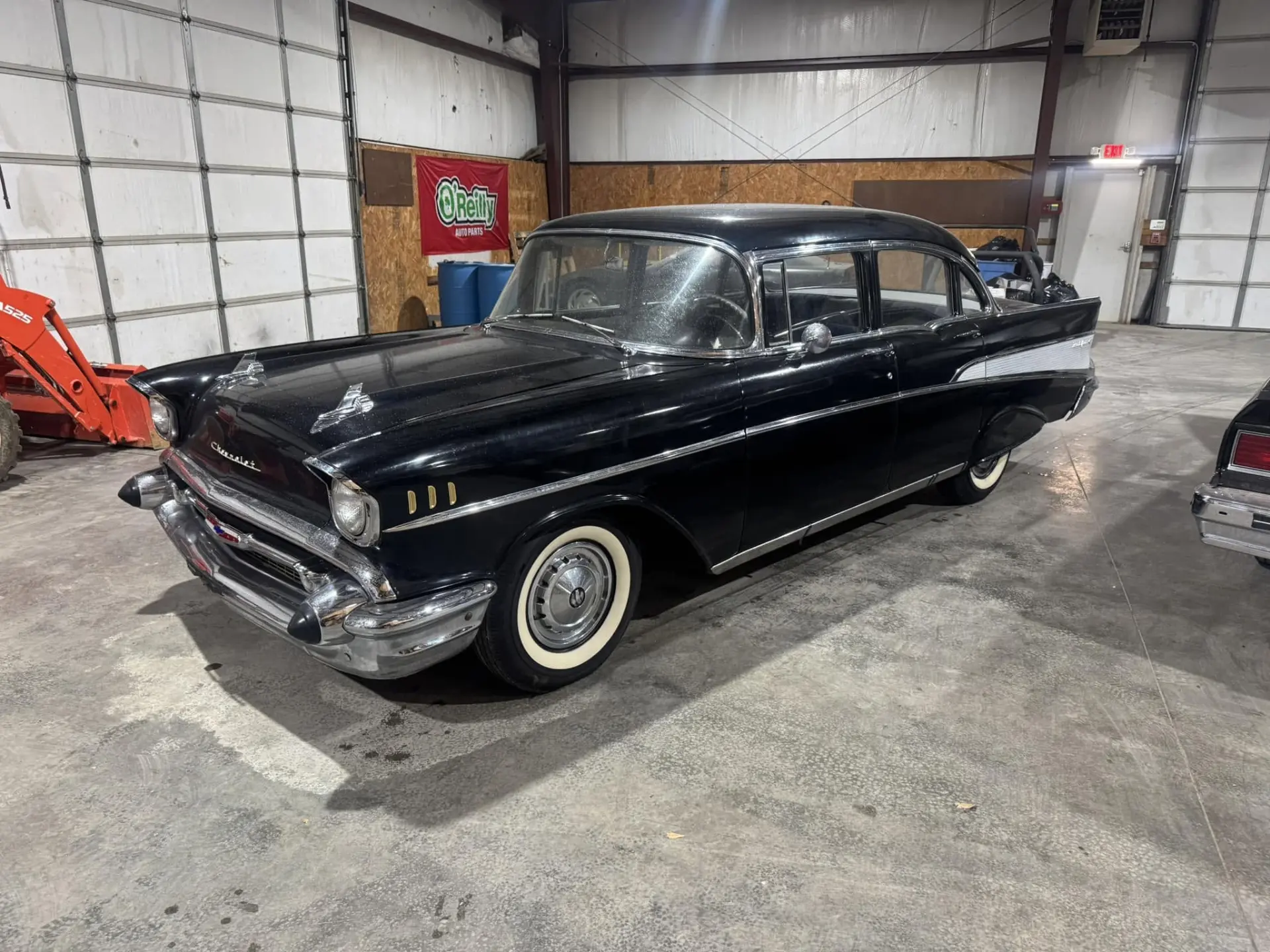 Black 1957 Chevrolet Bel Air sedan parked in the shop