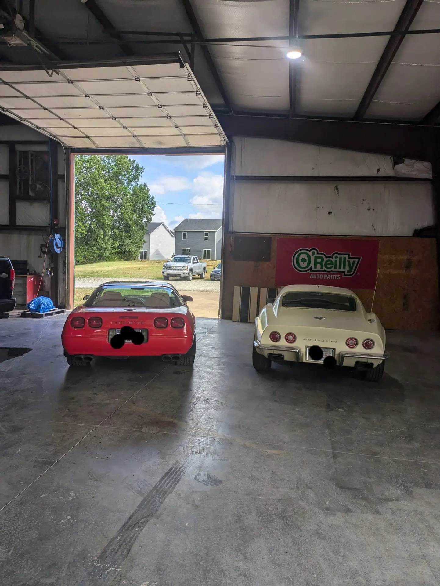 Two Corvettes parked in the open bay at All Roads Auto